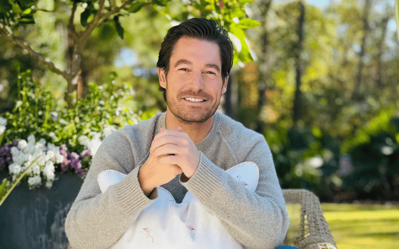 Craig Conover holding a large throw pillow