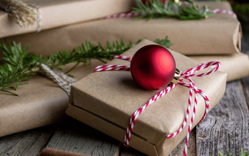 gift boxes wrapped in brown paper with a red string on top