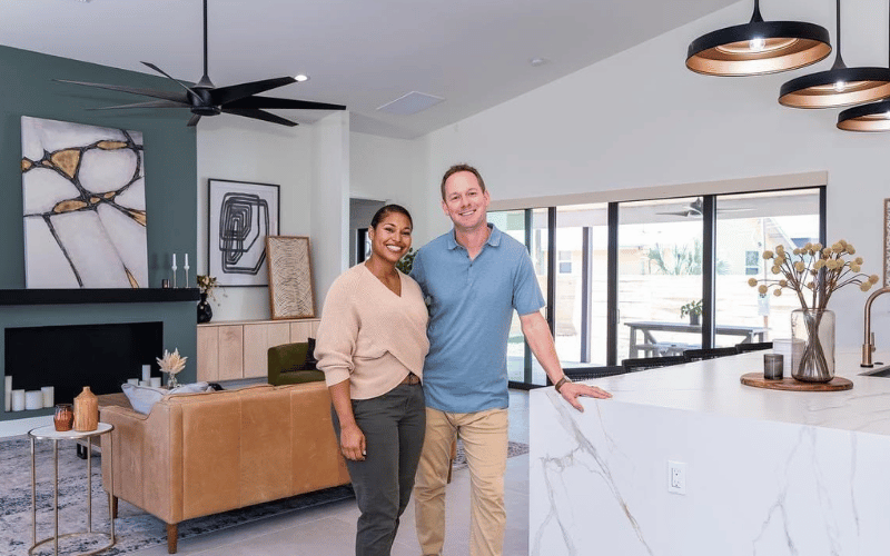 Brian and Mika Kleinschmidt standing in a large home living room 