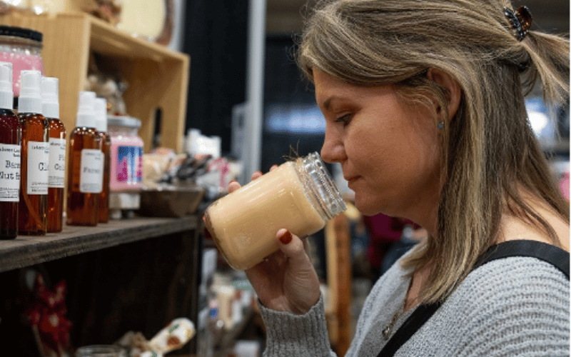 a woman smelling a large scented candle