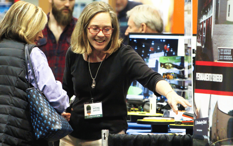 women pointing at products on table at the Birmingham Home Show