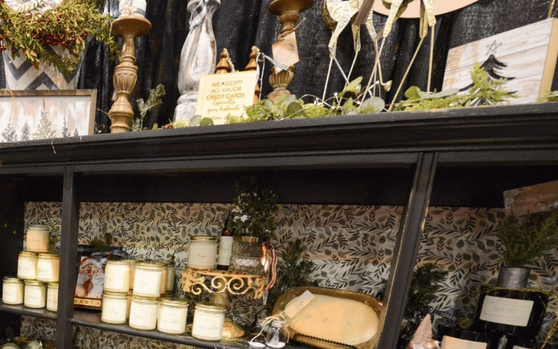 6 black shelf displaying candles and home goods