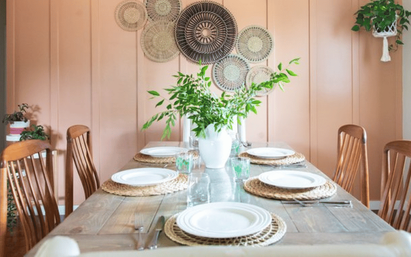 a dining table with plates and a vase on top