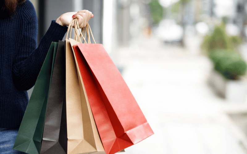 woman holding 3 shopping bags 