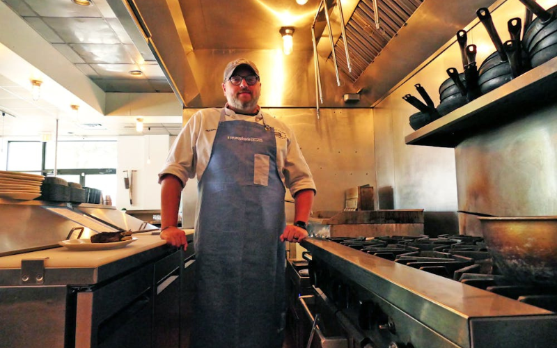 Chef Dallas McGarity standing inside compact food truck professional kitchen