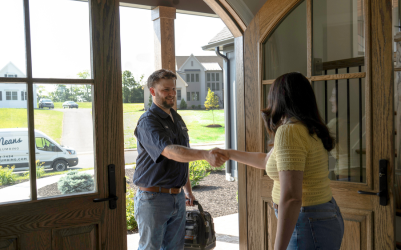 Bob Means Plumbing Bob Means Plumbing shaking hand of customer at door to residential home