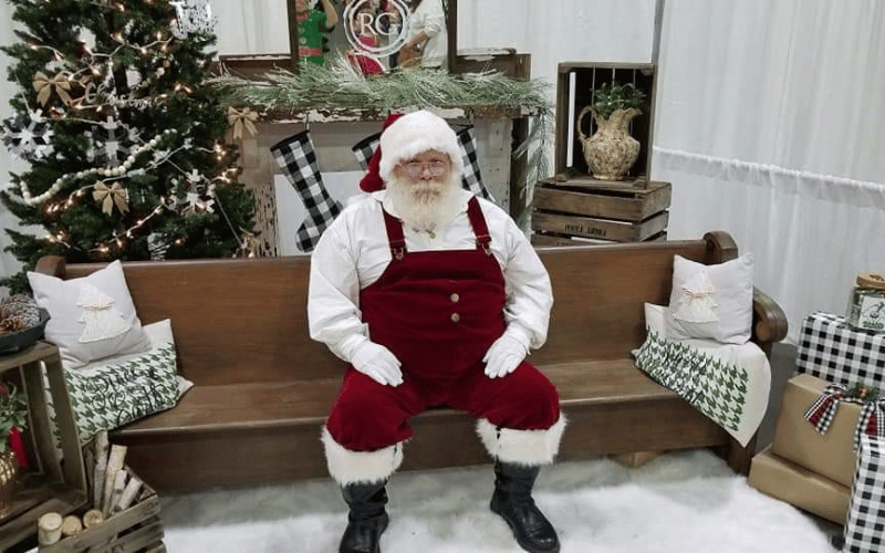 Santa Claus sitting on a wooden bench waiting to take photos with children