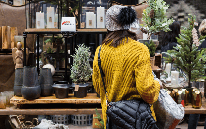 A woman wearing a yellow sweater Christmas shopping at the show