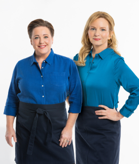 Bridget and Julia posing wearing matching blue shirts