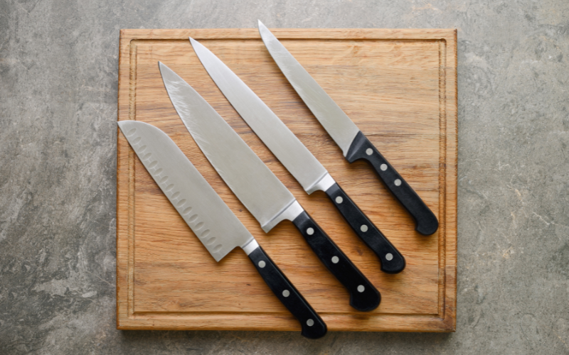 kitchen knives laid out across wooden cutting board