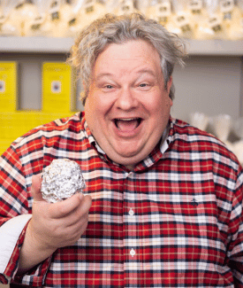 Patric Richardson the Laundry Guy holding a tin foil ball smiling wearing red plaid shirt