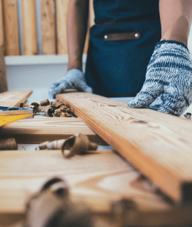 Measure twice cut once gloved hands measuring wooden board