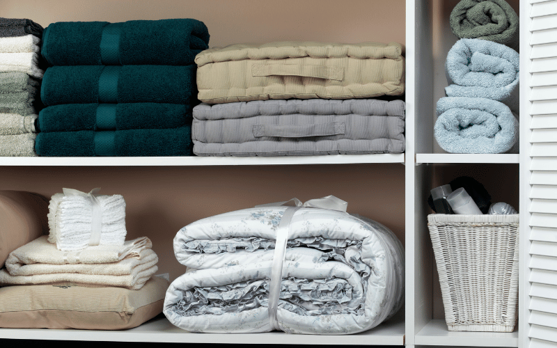 Folded towels and sheets nicely organized in a closet