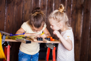 Two young girls using tools