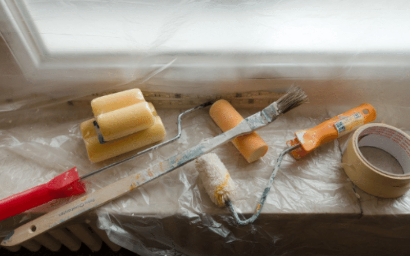 Drywall and painting supplies on window sill on top of protective plastic 