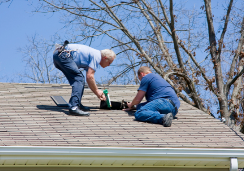 Two contractors working on roof