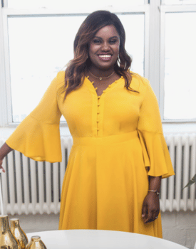 Celebrity Ati Williams wearing bright yellow dress smiling for camera