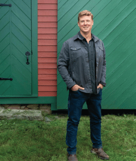 Kevin O Connor Headshot standing on grass in front of green barn doors