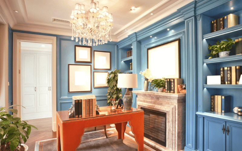 a bright orange desk with a blue book shelf 