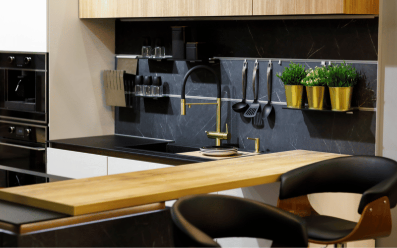 Modern wooden kitchen breakfast bar with brown and black leather bar stools