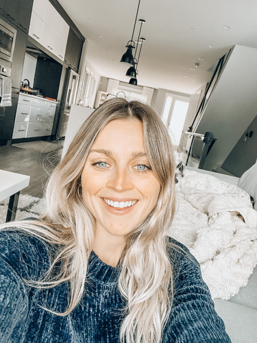 Heather Campbell selfie with soft dark green sweater and white sherpa on couch behind her