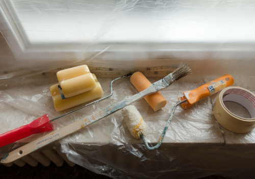 Painting and sanding hardware on drop cloth on window sill