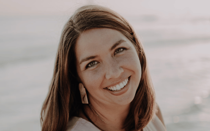 a woman posing by the beach wearing statement earrings 