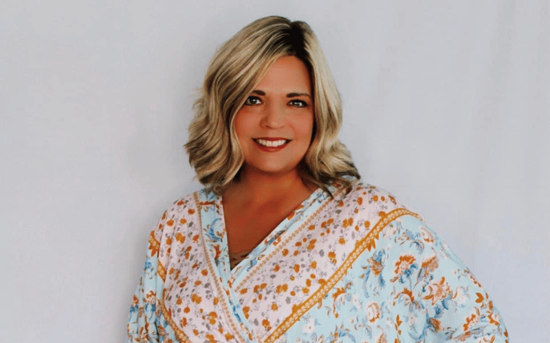 a photo of a woman posing wearing a blue and orange printed top 