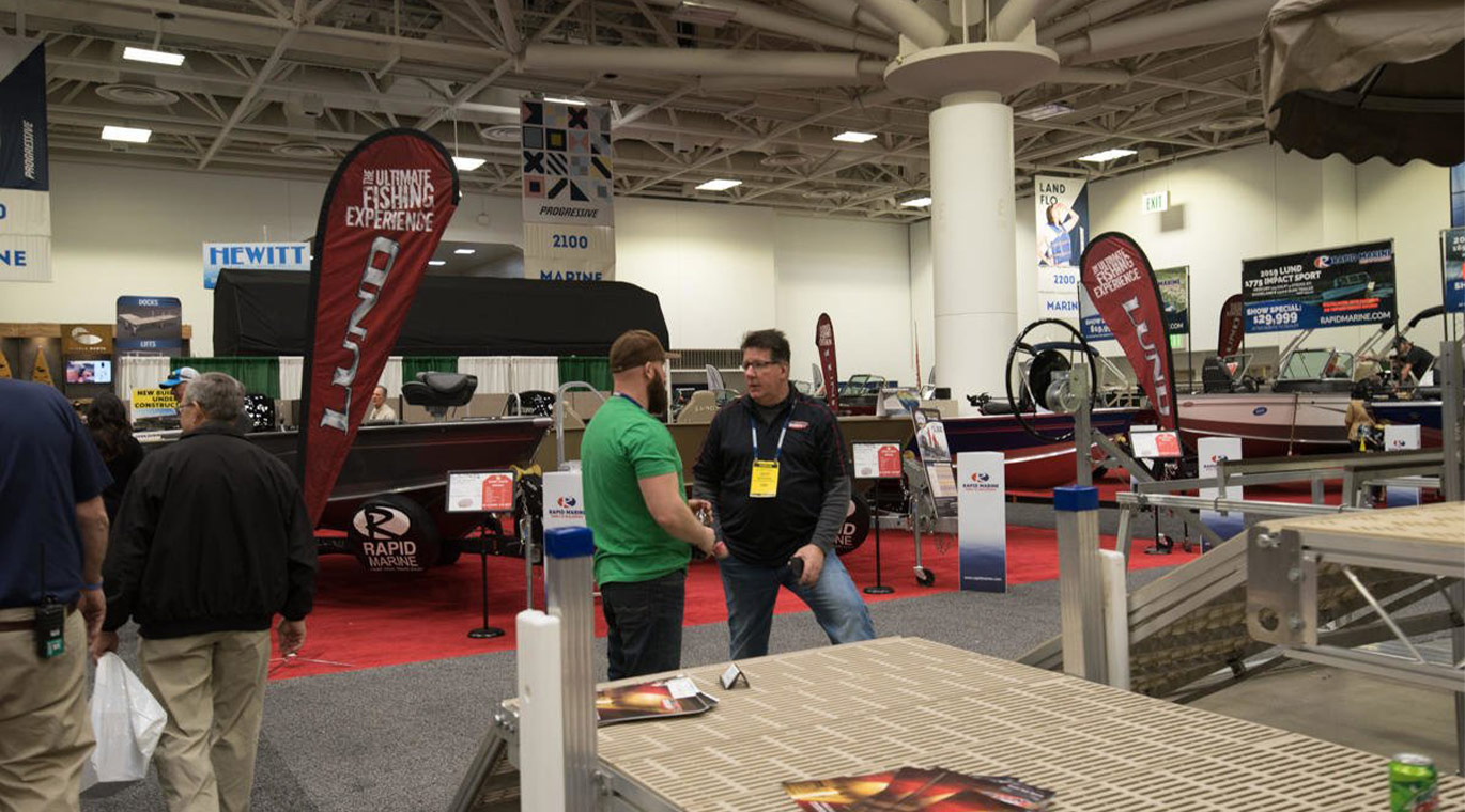 An exhibitor speaking with a guest at the Northwest Sportshow